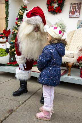 Madlyn Vero, 4, of Hackettstown gets a quick word with Santa before a line of children forms to sit on his lap.