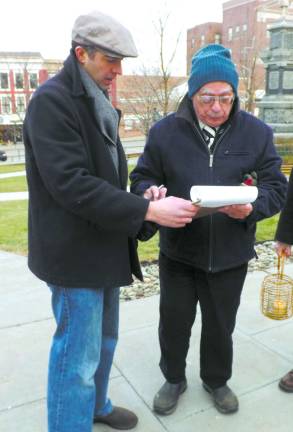 Robert Brennan (right) of Andover signing a petition to close the Guantanamo Bay Detention Center. At left is Mike Aloi of Sparta, the president of the local Amnesty International chapter.