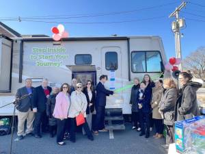 Rep. Tom Kean, R-7, cuts the ribbon on PSS Journey, a mobile-services vehicle operated by Project Self-Sufficiency. The ceremony in Hackettstown was attended by other officials. (Photo provided)