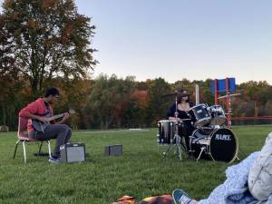 Devon Kumar and DJ Hannon in action playing guitar and drum