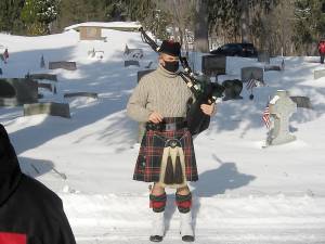 Bagpiper John Loggie tunes up before wreaths are placed (Photo by Janet Redyke)