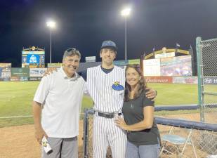 Christian Capuano stands with his family on the ball field.