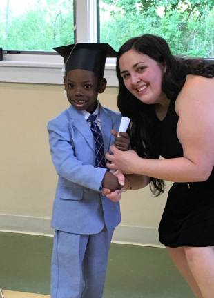 Little Sprouts Early Learning Center preschool graduate Josh Gaspard receives his diploma from teacher Leann Eaton. (Photo provided)
