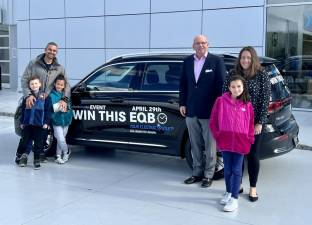 Tim Allocca of Mercedes-Benz of Newton congratulates the Amin family of Sparta. They won a two-year lease of a 2023 Mercedes-Benz EQB, an electric vehicle. Everyone age 21 and older who took a test drive of an electric vehicle during the dealership’s Electric Dream Days event April 29 was entered in the raffle. (Photo provided)