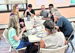 The Reverend Chris Streeter and the Reverend Patricia Lyons converse with Emily Jerger, Project Self-Sufficiency, and attendees at the New Beginnings Community Breakfast at Christ Church Newton.