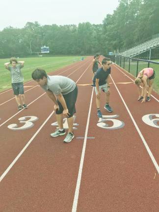 (From left to right): Kittatinny runners Kai Pender, Josh Langley, Ryan Alviani, and Bridget O'Keefe recover after running track intervals.