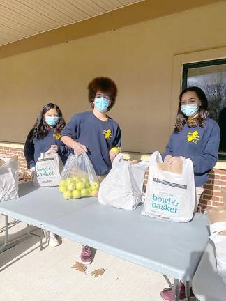 Project Self-Sufficiency Youth Corps members (from left): Kelly Tapia, Xavier Gonzalez and Adrianna Smith help bag turkey dinners (Photo by Laurie Gordon)