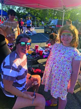 TN3 Sadie Blankenship, 8, of Dumfries, Va., has a rainbow on her forehead. It was painted by Carla Brunelle who worked in the face-painting tent along with other Newton High School seniors.