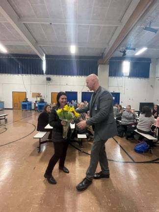 Timothy McCorkle, principal of Byram Intermediate School, presents flowers to paraprofessional Kerri Lyman. She received a Governor’s Educator Service Professional of the Year award.