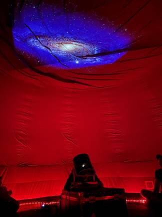 Stars and planets are projected on the top of the indoor planetarium. (Photo by Clara Docherty)