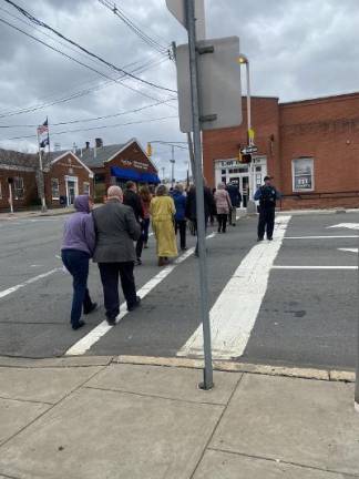 Parishioners march back up to the church with a police escort at the cross walk.