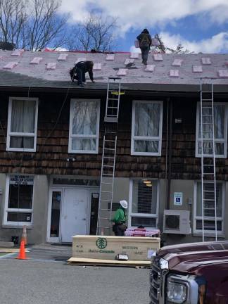Workers replace the roof of the post March 15. All the roofing materials were donated by Owens Corning, and Lowe’s paid the $37,000 cost of the work.