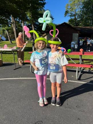 HH4 Second-graders Giana Zweig, left, and Reagan Campbell model balloon flower headdresses.