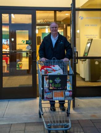 ST5 Keith Niedelgal of Hamburg, senior vice president/regional administrator at Lakeland Bank, pushes a shopping cart full of food.