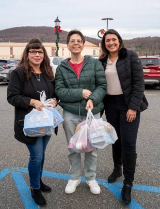 From left, Julie Perone, Mona De Groap and Stacy Moore drop off food.