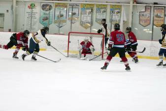 Vernon’s Rick Bennett, second from left, hits the puck toward the goal in the second period of the game against Newton/Lenape Valley on Feb. 3. Vernon won, 11-6. (Photos by George Leroy Hunter)