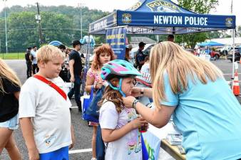 Rosalina Desibio has her bike helmet fitted during National Night Out on Tuesday, Aug. 5 in Newton. At left is Brentley Foutch. (Photos by Maria Kovic)