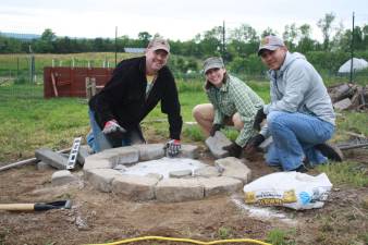 Salt Shaker members Jerry Covell, Tiffany Heineman and Mario Rodriguez build a fire pit for the recreation area at Sunset Vista Community Garden &amp; Learning Center in Andover.