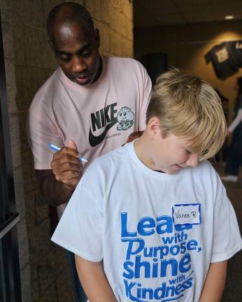 <b>Keynote speaker Cornell Thomas signs a student’s shirt.</b>