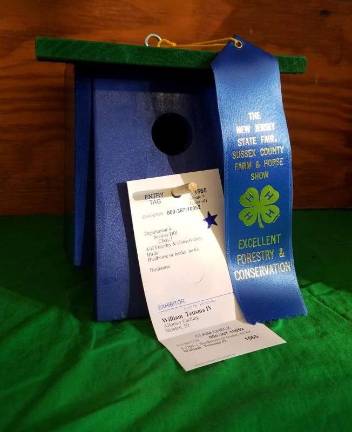 Blue ribbon birdhouse on display in the Shotwell 4-H Building, made by William Teitsma, IV of the 4-H Group &quot;Allons-y Caching&quot;.