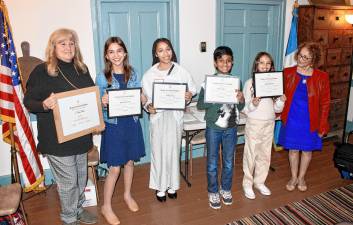 <b>From left are Natalie Takacs, chosen as 2025 Outstanding Teacher of American History; eighth-grade essay contest winner Maya Mianowski of Ogdensburg School; seventh-grade winner Katelyn Tedesco; sixth-grade winner Ahrin Kabse; fifth-grade winner Mikayla Baritista; and Allyn Perry, chairwoman of the essay contest. The winners in grades 5-7 attend Hilltop Country Day School. (Photo provided)</b>