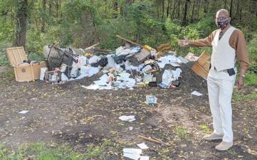 Vernon Township Mayor Howard Burrell stands by a pile of trash found at Maple Grange Park on Sept. 14.