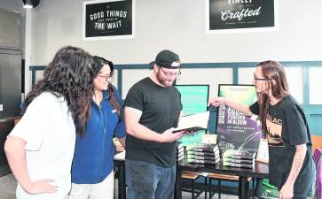 Sparta author Kelly Catlin points to a page in her book.