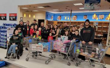 Ten children were accompanied by Sussex County Sheriff’s Officers and managers of Walmart of Newton on a shopping spree Dec. 21 at Benny’s Bodega in Newton. (Photo provided)