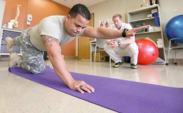 Capt. Israel Orengo is evaluated by physical therapist Tyler Snow at Madigan Army Medical Center in 2015. Snow was one of the researchers on an Army study that looked at incorporating alternative methods such as acupuncture and biofeedback into pain management.