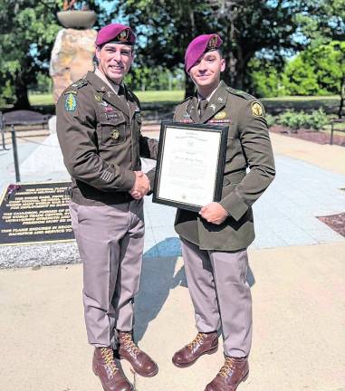 Stephen Rozek of Andover, right, poses with another officer and a certificate signifying his promotion to captain in the U.S. Army.