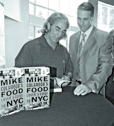 Celebrity chef Michael Colameco signs his latest book for Jim Furgeson, Director of Business Development and Physician Relations at Newton Medical Center.
