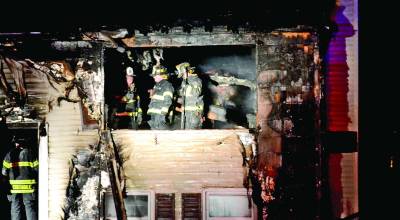 Photo courtesy of Sparta Police Department Sparta fire fighters stand in the charred remains of the living room on Foxtrail Road