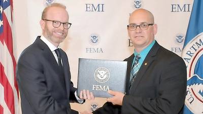 Corporal Mark Vogel, right, accepts his certificate from Dr. Daniel Kankiewski of the Federal Emergency Management Agency.
