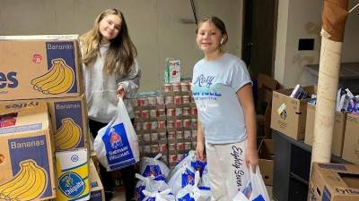 Olivia and Magdalene packing weekend bags out of their basement. The Costello girls’ nonprofit, created by their older sister Isobel, provides food and hygiene products to over 80 local students each week.