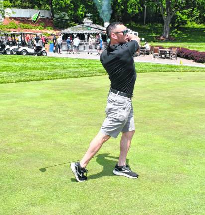 John Spoon of the Sparta Police Dept. drives his shot.