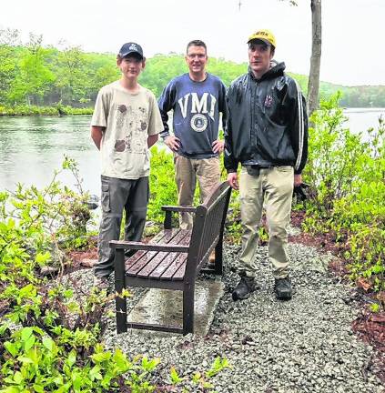 Life Scout Trey Hydock is shown with Assistant Scoutmasters Russ Raffay and James Braun in front of new bench with a view of Johnson Pond