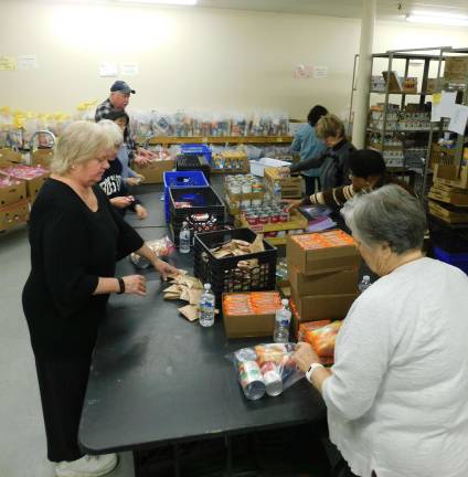Volunteers from the Panther Valley Ecumenical Church pack &quot;weekend bags&quot; at the Sussex County Food Pantry on Thursday, Jan. 17, 2019. The bags are distributed to four local school districts to help food insecure students fill the food gap between meals at school.&#xa0;(Photo by Mandy Coriston).
