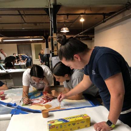 From left, Natalie Fung, Jennifer Ellsworth and Lauren Hennighan paint a section of the mural.