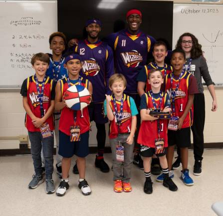 The Wiz Kids, wearing Harlem Wizards jerseys, pose with the players.