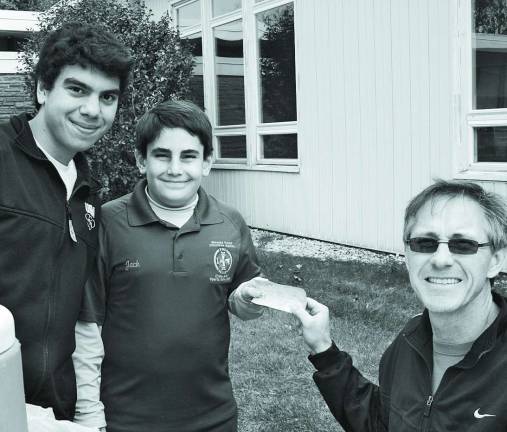 Squire co-captains Dominick Bartolomeo and Jack Lubertazzi present donation check to Reverend Randy Parks
