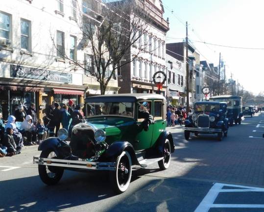 A line of antique cars from the Model A Ford Club of New Jersey makes its way up Spring Street in Newton during the Annual Holiday Parade on Saturday, Nov 30, 2019.