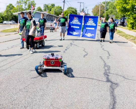 High school students show off their robot in the parade.