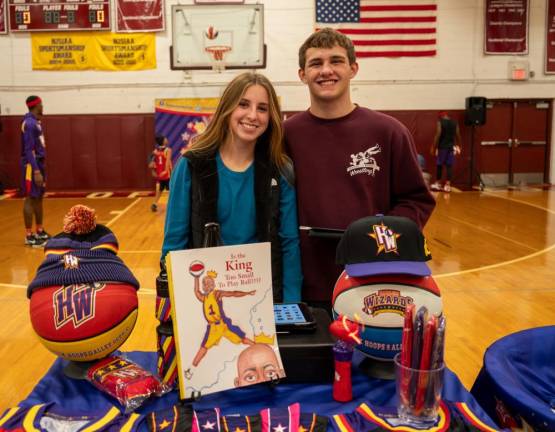Emma Eigner and Aaron Stone with Harlem Wizards items for sale at the game.