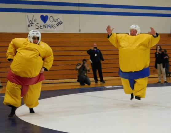 Business teacher and event organizer Theresa Iliff (L) eludes head wrestling coach John Gill during a sumo suit wrestling match, at a fundraiser held at KRHS on Wednesday, May 15, 2019.