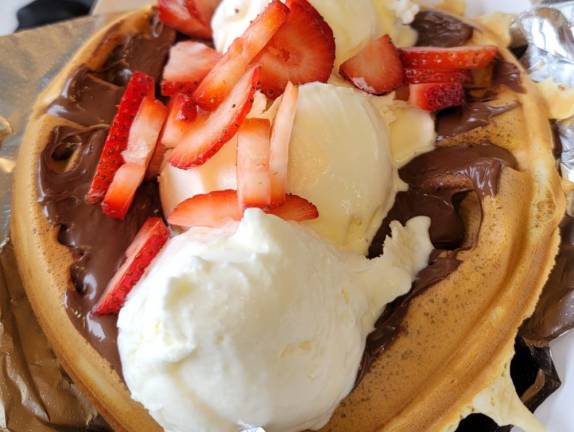 A waffle loaded with nutella, ice cream, and strawberries from The Wicked Waffle Stick.
