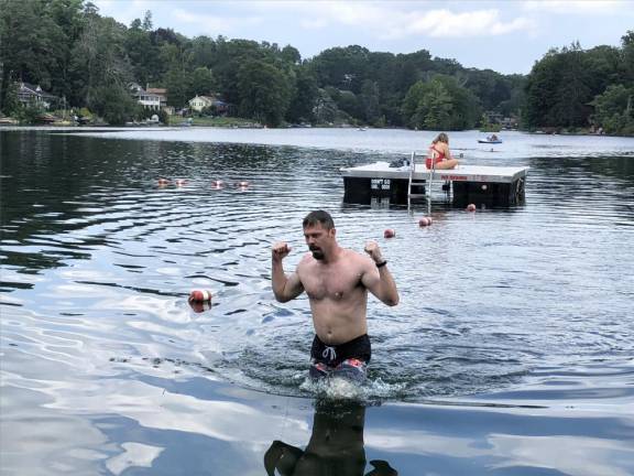 Brian Ogilvie celebrates his first-place finish in the Lindy’s Lake Distance Swim. (Photo by Kathy Shwiff)