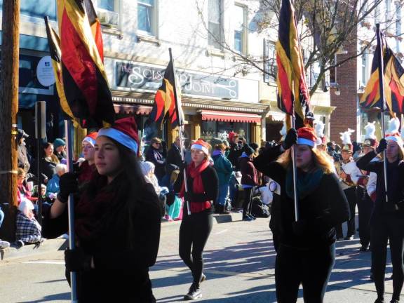 The Newton High School Marching Braves color guard leads the band up Spring Street in Newton during the Annual Holiday Parade on Saturday, Nov 30, 2019.