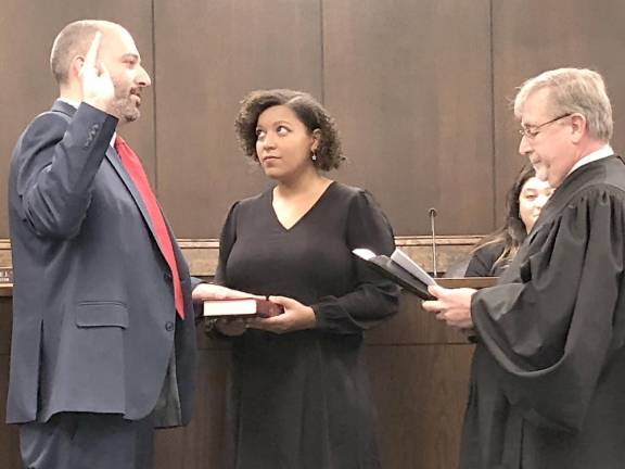 Councilman Matthew Dickson is sworn in for his second term by Municipal Court Judge James Sloan. Holding the Bible is his stepdaughter Olivia Webster.