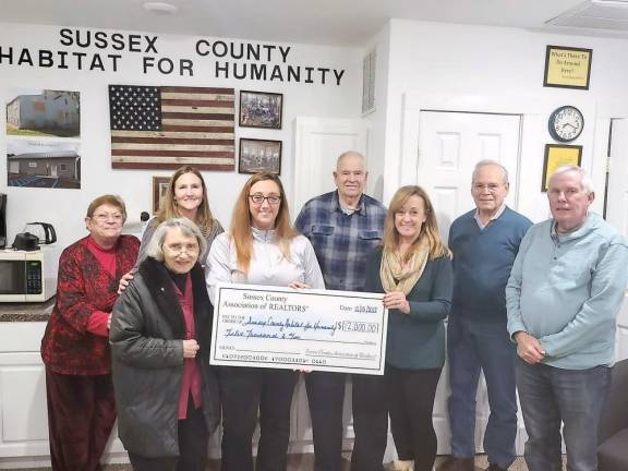Emily Bowden, fourth from left, of the Sussex County Association of REALTORS presents a check for $12,000 to the board of directors of the Sussex County Habitat for Humanity in Newton. From left are Jan Miglin, Carolyn King, Pam Vreeland, Bowden, board president Ken Landrud, Sandy Gardner, Jim Ciaravolo and Wade Abbott. (Photo provided)