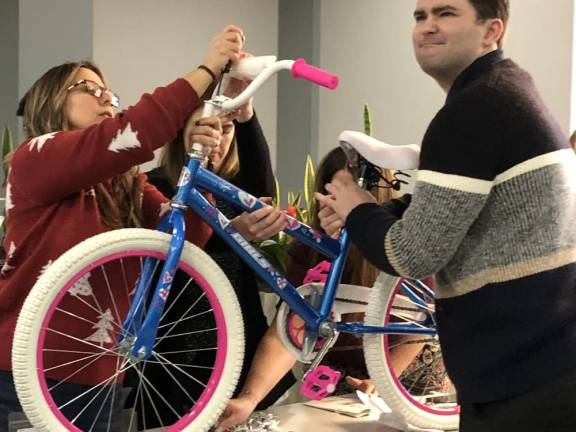 A team of Selective Insurance employees assemble a child’s bicycle.